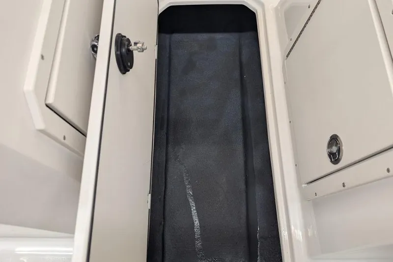 Slide: The Image of 2025 Starcraft SVX 210 IO boat storage compartment with open hatch and sleek interior design. - 9