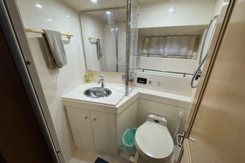 Slide: The Image of 1998 Carver 356 Aft Cabin bathroom with sink, toilet, and shower area. - 11