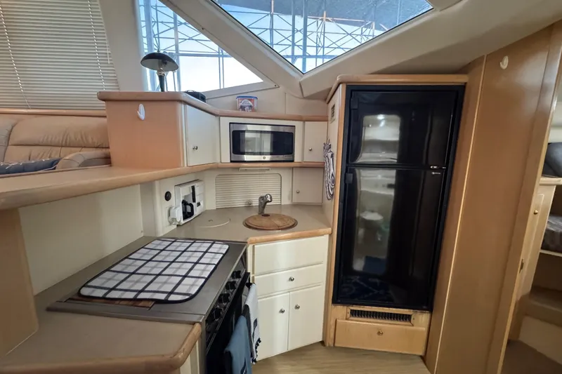 Slide: The Image of 1998 Carver 356 Aft Cabin kitchen with microwave, stove, and refrigerator. - 13