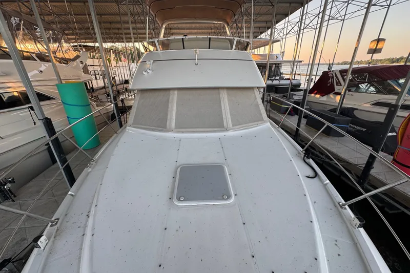 Slide: The Image of 1998 Carver 356 Aft Cabin yacht docked in a marina, viewed from the bow. - 3