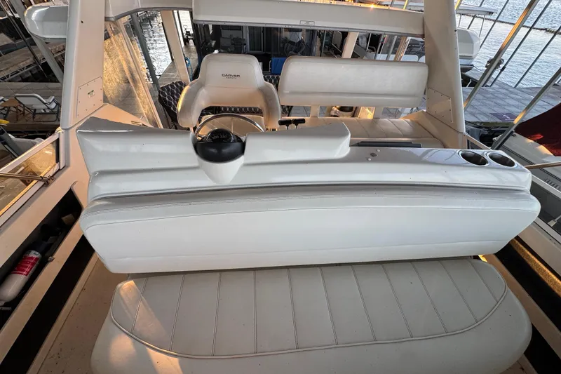 Slide: The Image of 1998 Carver 356 Aft Cabin boat interior with white seating and steering wheel. - 7