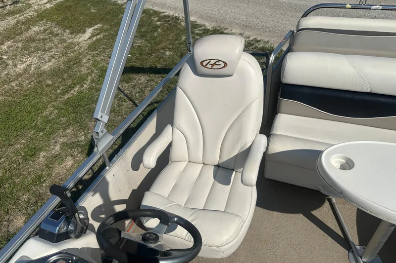 Slide: The Image of Captain's seat on 2005 Harris Classic 260 pontoon boat, featuring steering wheel and control panel. - 11