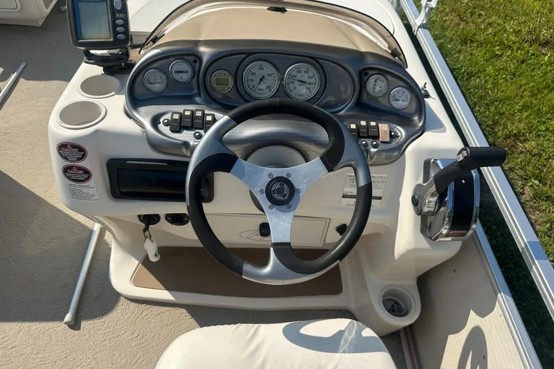 Slide: The Image of Steering console of a 2005 Harris Classic 260 boat with gauges and controls. - 13