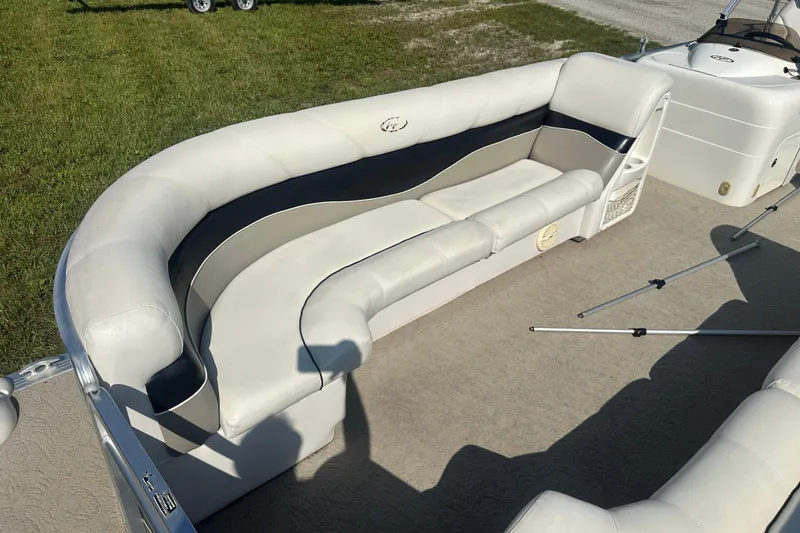 Slide: The Image of 2005 Harris Classic 260 boat interior with white cushioned seating and carpeted floor. - 5