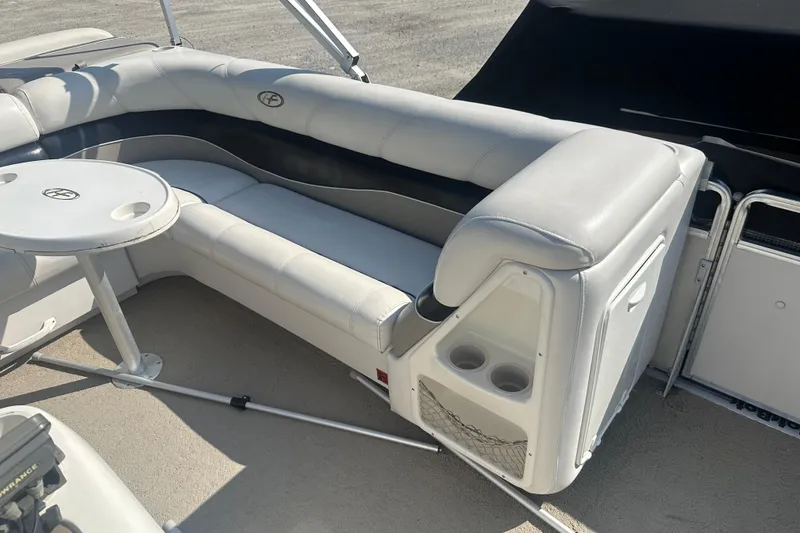 Slide: The Image of 2005 Harris Classic 260 boat interior with white seating and round table. - 8