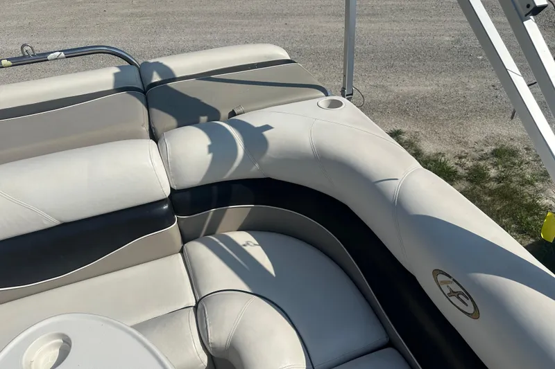 Slide: The Image of Luxurious seating on a 2005 Harris Classic 260 boat, featuring white and black upholstery. - 9