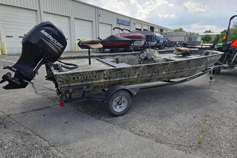 Slide: The Image of 2014 Ranger 1862 MPV boat with Mercury outboard motor, parked outside a warehouse. - 5