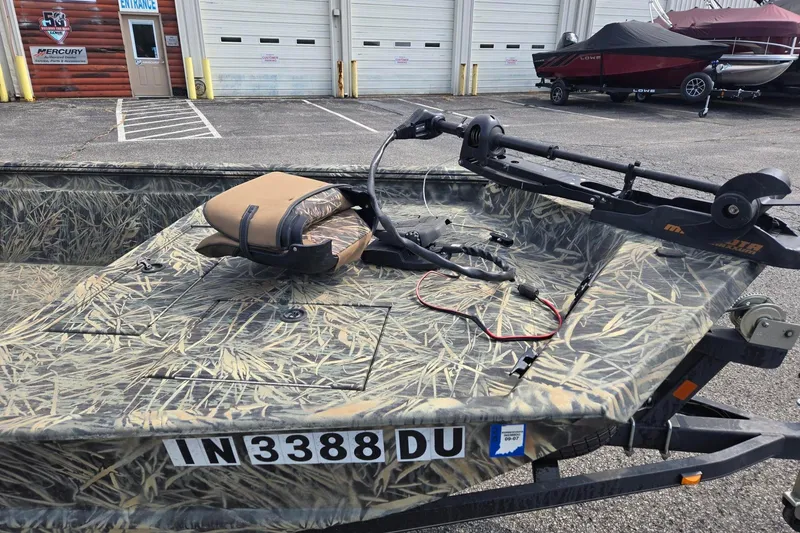 Slide: The Image of 2014 Ranger 1862 MPV boat with camouflage design and trolling motor in parking lot. - 7