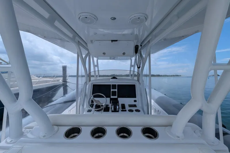 Slide: The Image of 2015 Yellowfin RIB boat cockpit with steering wheel and control panel, docked by calm waters. - 16