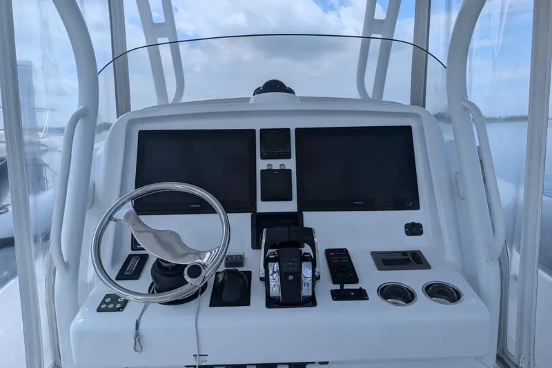 Slide: The Image of Control panel of a 2015 Yellowfin RIB boat with steering wheel and navigation screens. - 17