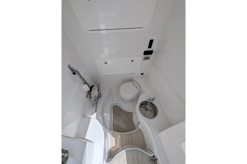 Slide: The Image of Interior of 2015 Yellowfin RIB boat featuring compact bathroom with toilet and sink. - 19