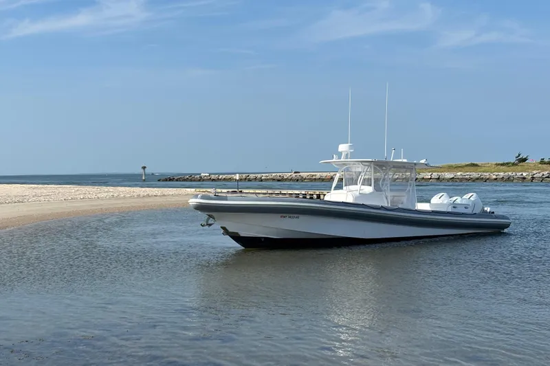 Slide: The Image of 2015 Yellowfin RIB boat anchored on a sandy beach with clear blue skies. - 5