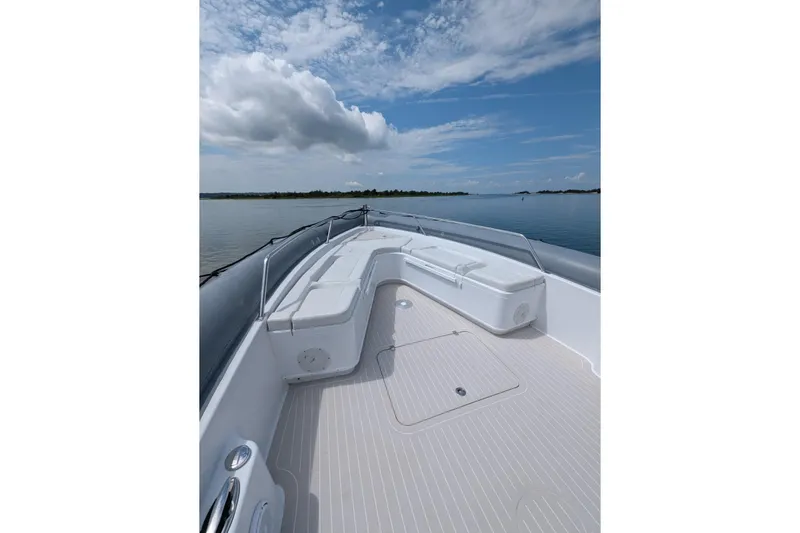 Slide: The Image of 2015 Yellowfin RIB boat deck with seating, calm water, and cloudy sky. - 8