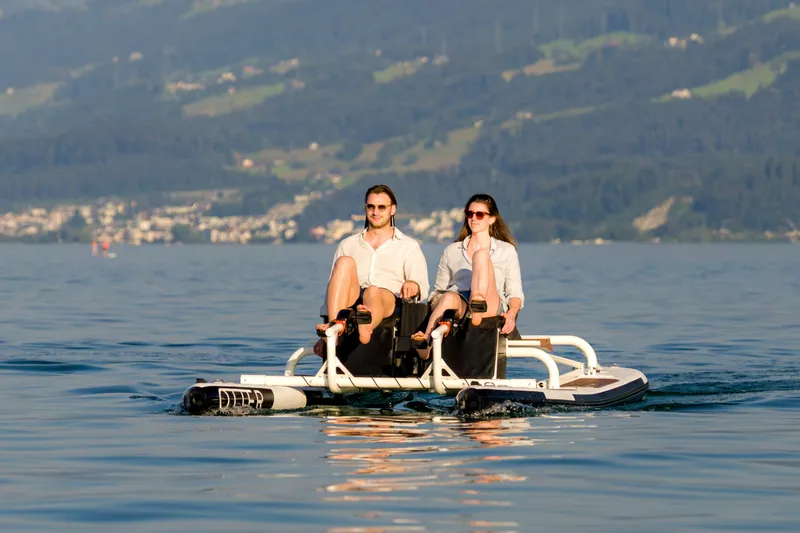 Slide: The Image of Couple enjoying a ride on a 2025 OTTER Otter Bike on a scenic lake. - 2