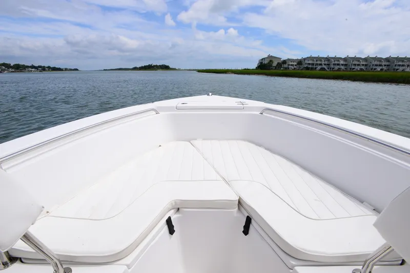 Slide: The Image of 2015 Sea Hunt Triton 210 boat with white seating, cruising on a calm waterway. - 10