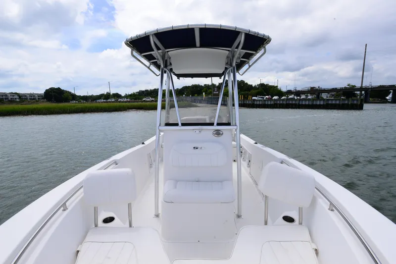 Slide: The Image of 2015 Sea Hunt Triton 210 boat on calm water, featuring a center console and seating. - 11