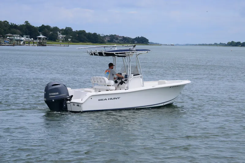 Slide: The Image of 2015 Sea Hunt Triton 210 boat cruising on a calm waterway. - 3