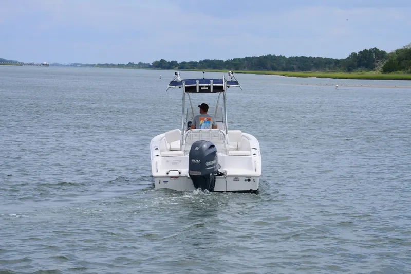 Slide: The Image of 2015 Sea Hunt Triton 210 boat cruising on a calm waterway. - 4