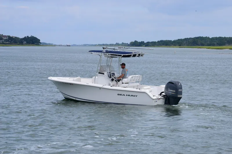 Slide: The Image of 2015 Sea Hunt Triton 210 boat cruising on calm waters with a Yamaha engine. - 5