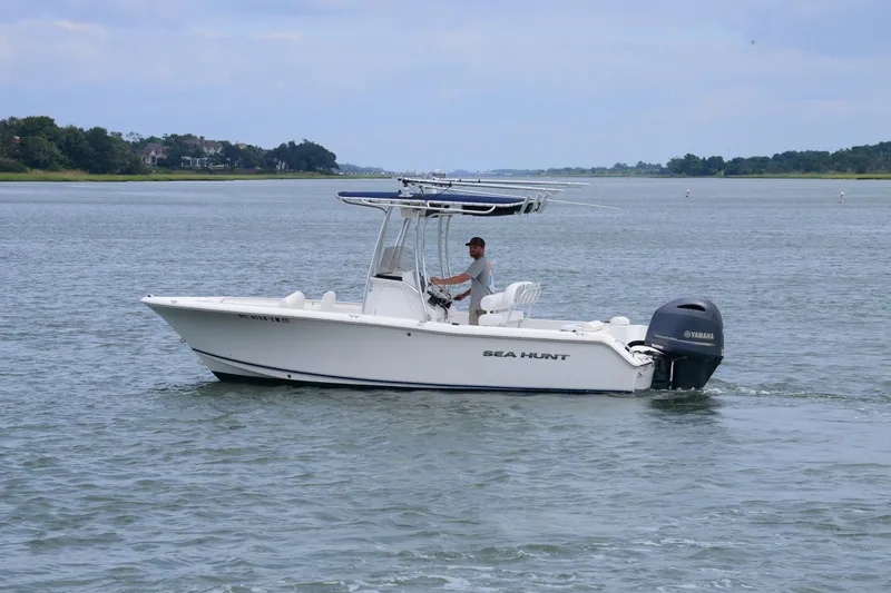 Slide: The Image of 2015 Sea Hunt Triton 210 boat cruising on calm waters with a Yamaha engine. - 6