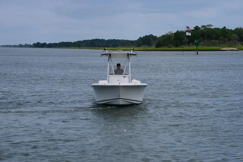 Slide: The Image of 2015 Sea Hunt Triton 210 boat cruising on a calm waterway. - 9