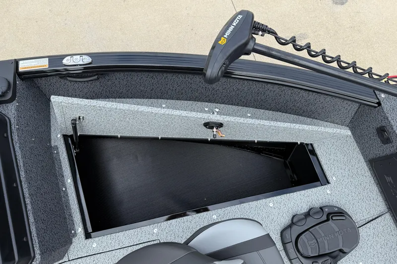 Slide: The Image of 2026 Lund 1800 Explorer Sport boat interior with storage compartment and Minn Kota trolling motor. - 10