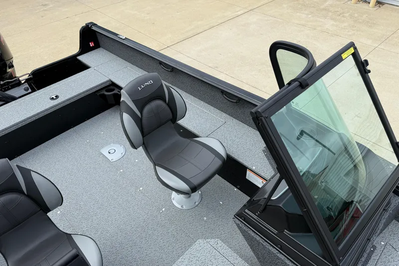 Slide: The Image of 2026 Lund 1800 Explorer Sport boat interior with seating and windshield. - 17