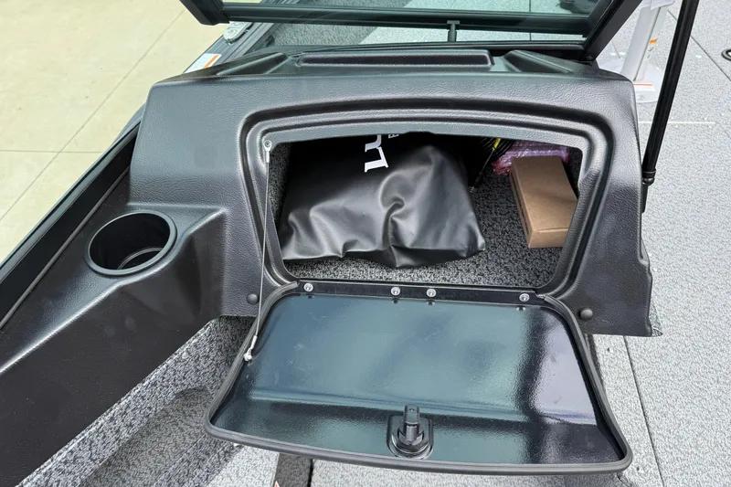 Slide: The Image of 2026 Lund 1800 Explorer Sport storage compartment with open hatch and cup holder. - 20