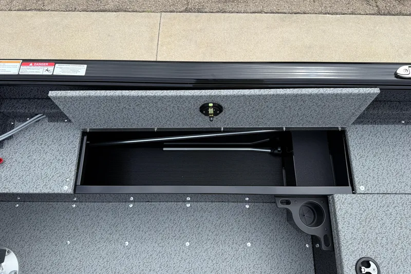 Slide: The Image of 2026 Lund 1800 Explorer Sport boat storage compartment with open lid, showcasing interior space. - 23