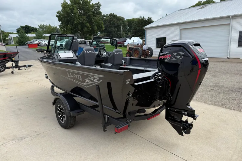 Slide: The Image of 2026 Lund 1800 Explorer Sport boat with Mercury Pro XS engine, parked outdoors. - 5