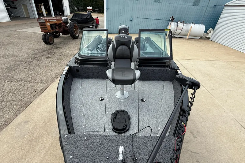 Slide: The Image of 2026 Lund 1800 Explorer Sport boat with seating and windshield, parked outdoors. - 8