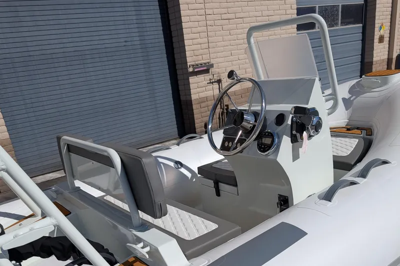 Slide: The Image of 2025 Tide Craft Nantucket 12 boat interior with steering wheel and seating. - 2