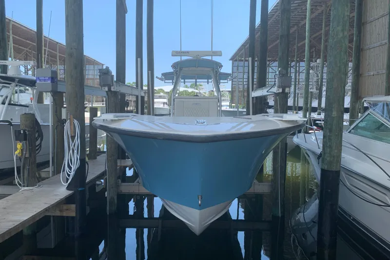 Slide: The Image of 2008 Invincible 36 CC boat docked in a marina, surrounded by other vessels. - 1