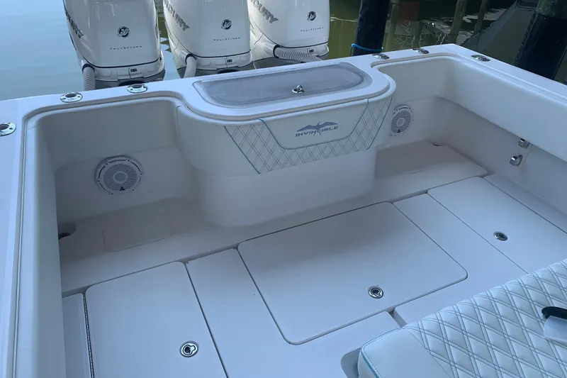 Slide: The Image of 2008 Invincible 36 CC boat interior with white seating and Mercury outboard engines. - 11