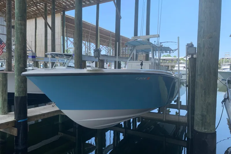 Slide: The Image of 2008 Invincible 36 CC boat docked in marina, blue hull, under covered shelter. - 3