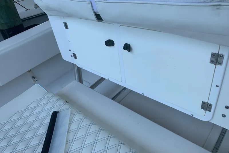 Slide: The Image of Interior view of a 2008 Invincible 36 CC boat, featuring storage compartments and cushioned seating. - 36