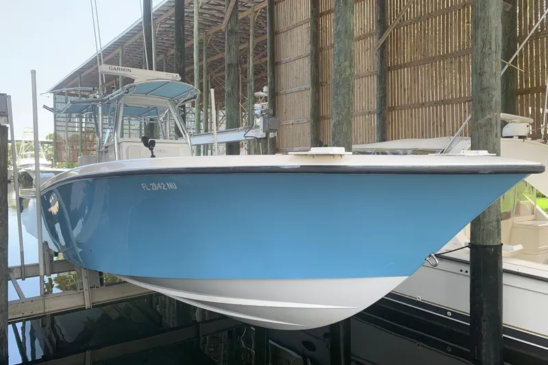 Slide: The Image of 2008 Invincible 36 CC boat in dry dock, featuring a sleek blue hull. - 4