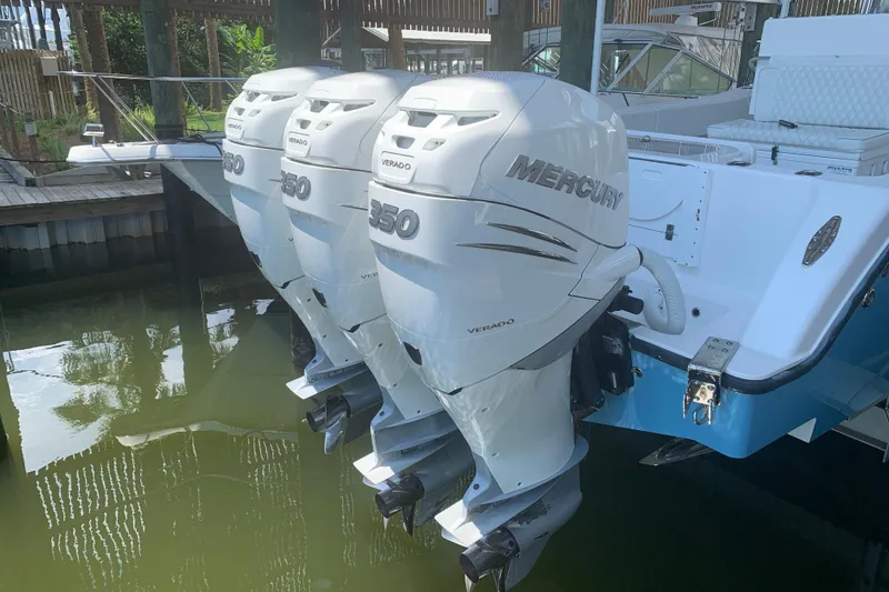 Slide: The Image of Triple Mercury Verado 350 engines on a 2008 Invincible 36 CC boat docked in water. - 5