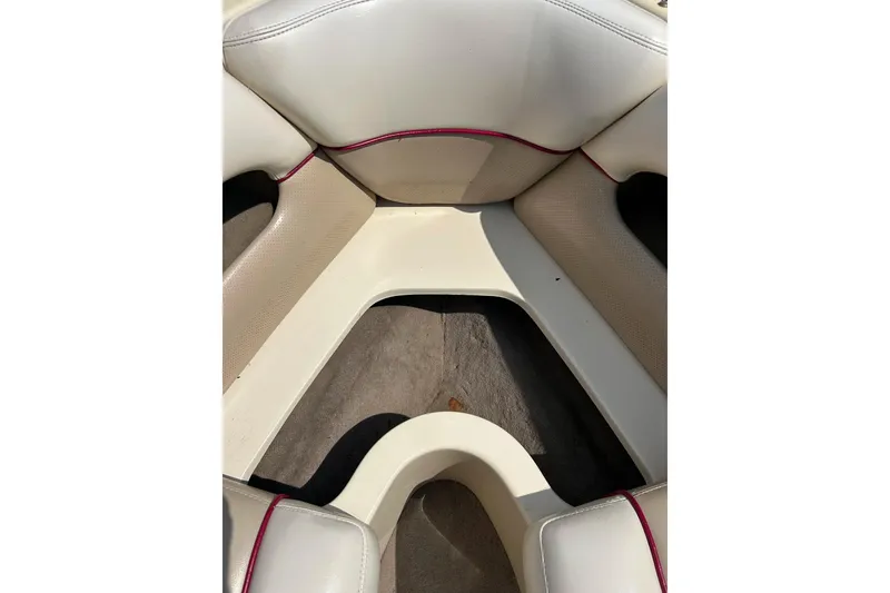 Slide: The Image of Interior seating of a 1999 Malibu Sunsetter VLX boat with beige upholstery. - 10