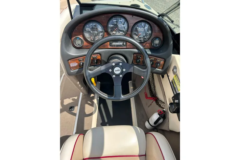 Slide: The Image of 1999 Malibu Sunsetter VLX boat dashboard with steering wheel and gauges. - 11