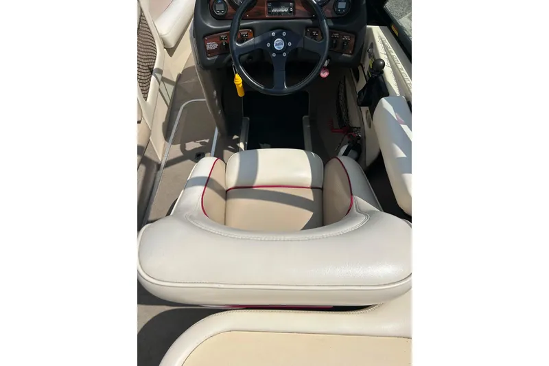 Slide: The Image of 1999 Malibu Sunsetter VLX boat interior with steering wheel and beige seating. - 12
