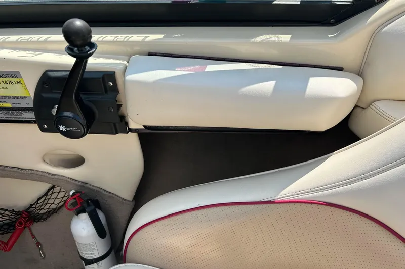 Slide: The Image of Interior of a 1999 Malibu Sunsetter VLX boat with control lever and fire extinguisher. - 13