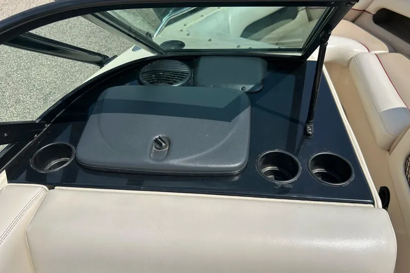 Slide: The Image of 1999 Malibu Sunsetter VLX boat interior with cup holders and storage compartment. - 16