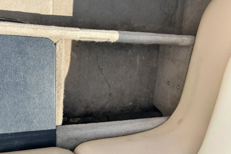 Slide: The Image of Interior view of a 1999 Malibu Sunsetter VLX boat, showing seating and storage area. - 19