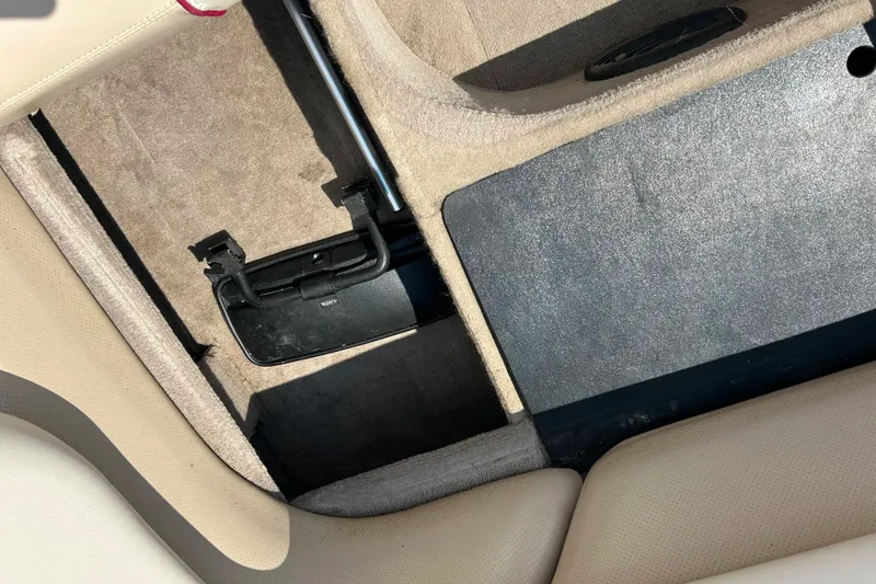 Slide: The Image of Interior view of a 1999 Malibu Sunsetter VLX boat, showing storage compartments. - 22