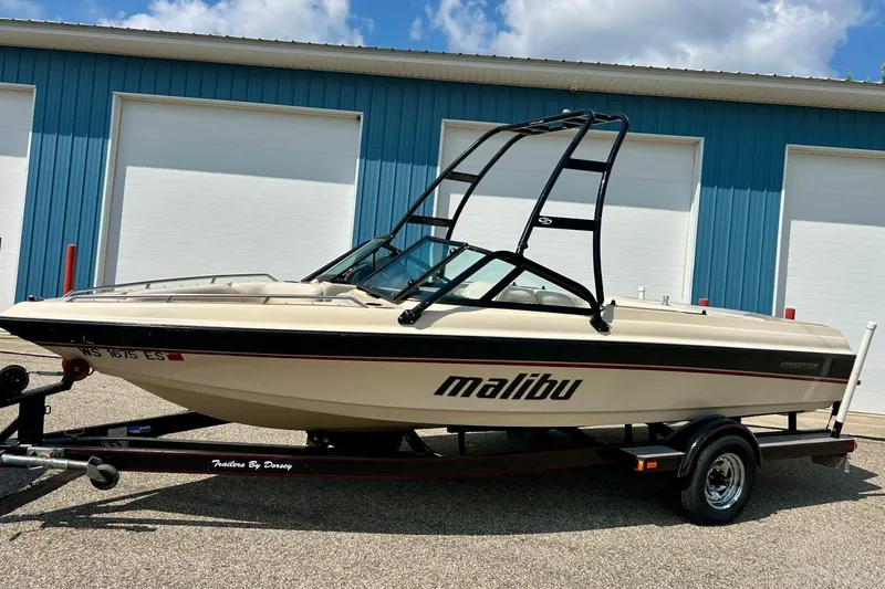 Slide: The Image of 1999 Malibu Sunsetter VLX boat on trailer, parked outside blue building. - 32