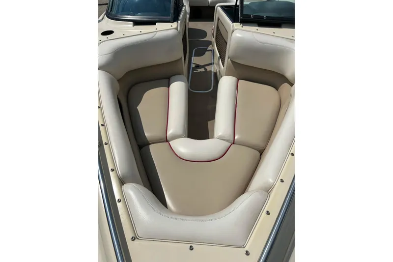 Slide: The Image of 1999 Malibu Sunsetter VLX boat interior with beige seating and red accents. - 5