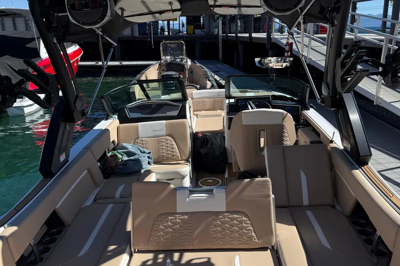 Slide: The Image of 2025 MasterCraft X24 boat interior with luxurious seating and modern dashboard at a dock. - 4