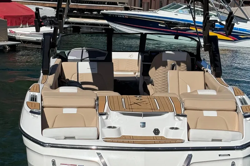 Slide: The Image of 2025 MasterCraft X24 boat with luxurious seating, docked at a marina. - 5