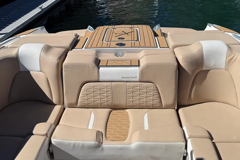 Slide: The Image of 2025 MasterCraft X24 boat interior with beige seating and teak accents. - 6